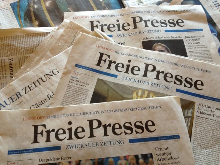 Mehrere Auflagen der Zeitung &bdquo;Freie Presse&ldquo; in Zwickau liegen &uuml;bereinander auf einem Tisch.