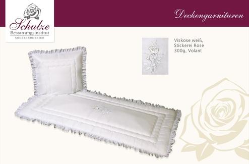Weißes Bettwäsche-Set aus Viskose mit Rosestickerei und voluminösem Volant auf gefranstem Kissen und Decke.
