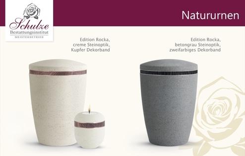Zwei Natururnen der Edition Rocka: eine in cremefarbener Steinoptik mit Kupferband und eine in betongrauer Optik mit zweifarbigem Band.