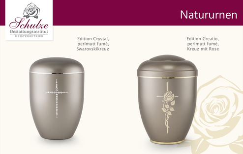 Zwei elegante Natururnen in perlmutt-fum&eacute;, eine mit Swarovski-Kreuz und die andere mit Rosenmotiv.