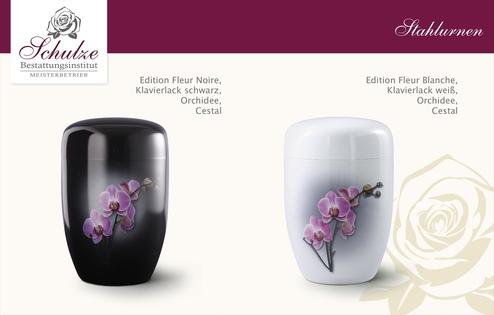 Zwei stilvolle Stahlurnen in Schwarz und Weiß mit Orchideenmotiven auf einer neutralen Hintergrundfläche.