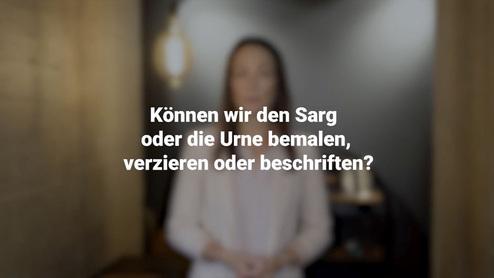 Frau in blasser Bluse steht vor einem unscharfen Hintergrund, w&auml;hrend sie die Frage zu Sarg- und Urne-Gestaltung stellt.