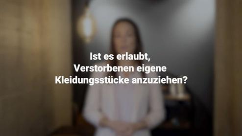 Eine Person steht vor einer unscharfen Hintergrundszene mit der Frage: "Ist es erlaubt, Verstorbenen eigene Kleidungsstücke anzuziehen?"