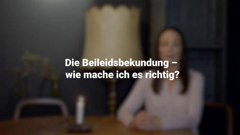 Sicht auf eine Frau vor einem Tisch, mit einer Lampe, w&auml;hrend sie &uuml;ber Beileidsbekundungen spricht.