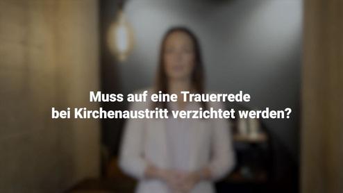 Frau in blauer Bluse steht vor einer Wand und diskutiert das Thema Trauerrede bei Kirchenaustritt.
