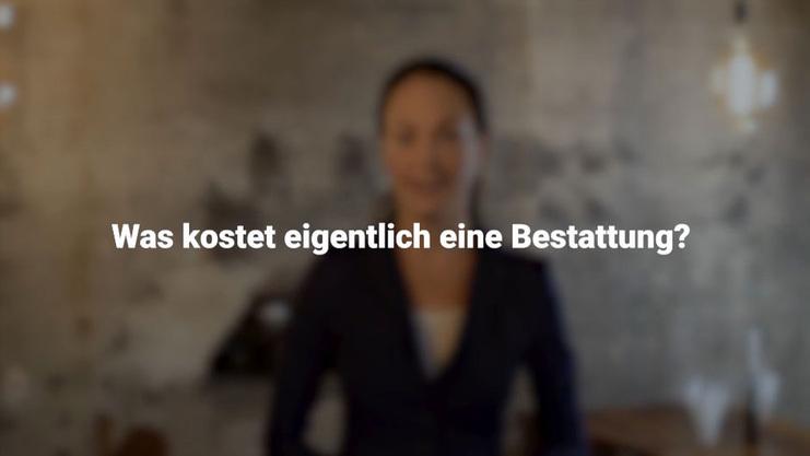 Unsch&auml;rfe mit Fokus auf eine Frau in einem schwarzen Blazer vor einer grauen Wand, auf die Frage zur Bestattungskosten.