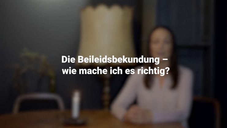 Sicht auf eine Frau vor einem Tisch, mit einer Lampe, w&auml;hrend sie &uuml;ber Beileidsbekundungen spricht.